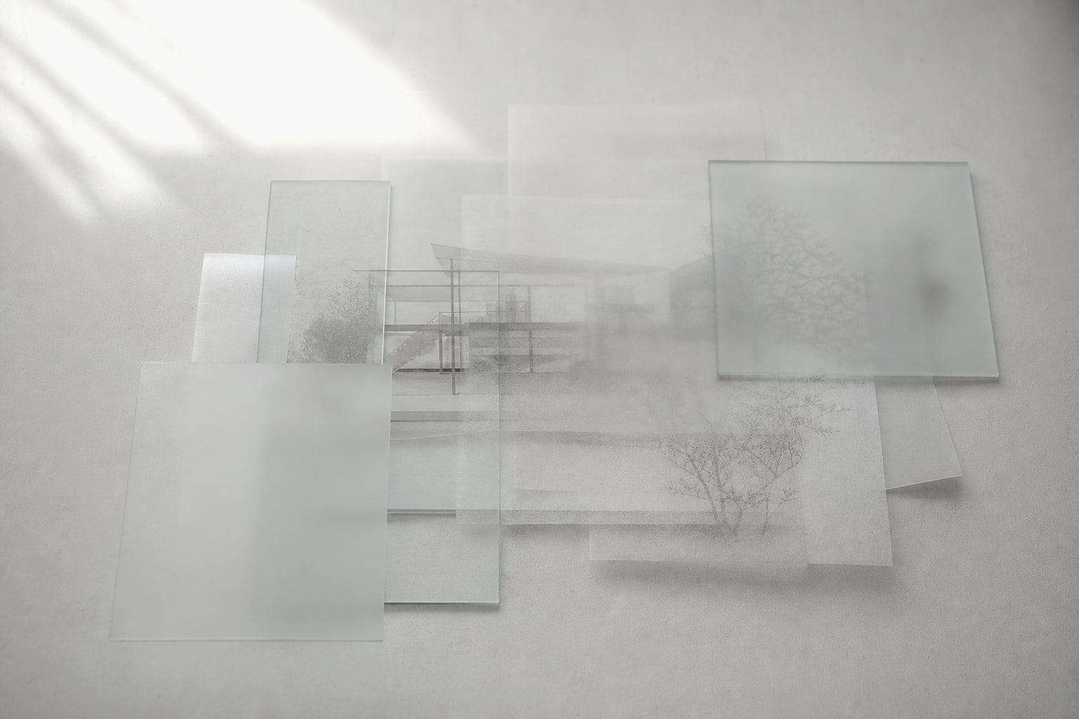 半透明の紙とガラスが重なり、建築の構造が見える部分と隠れる部分に分かれている